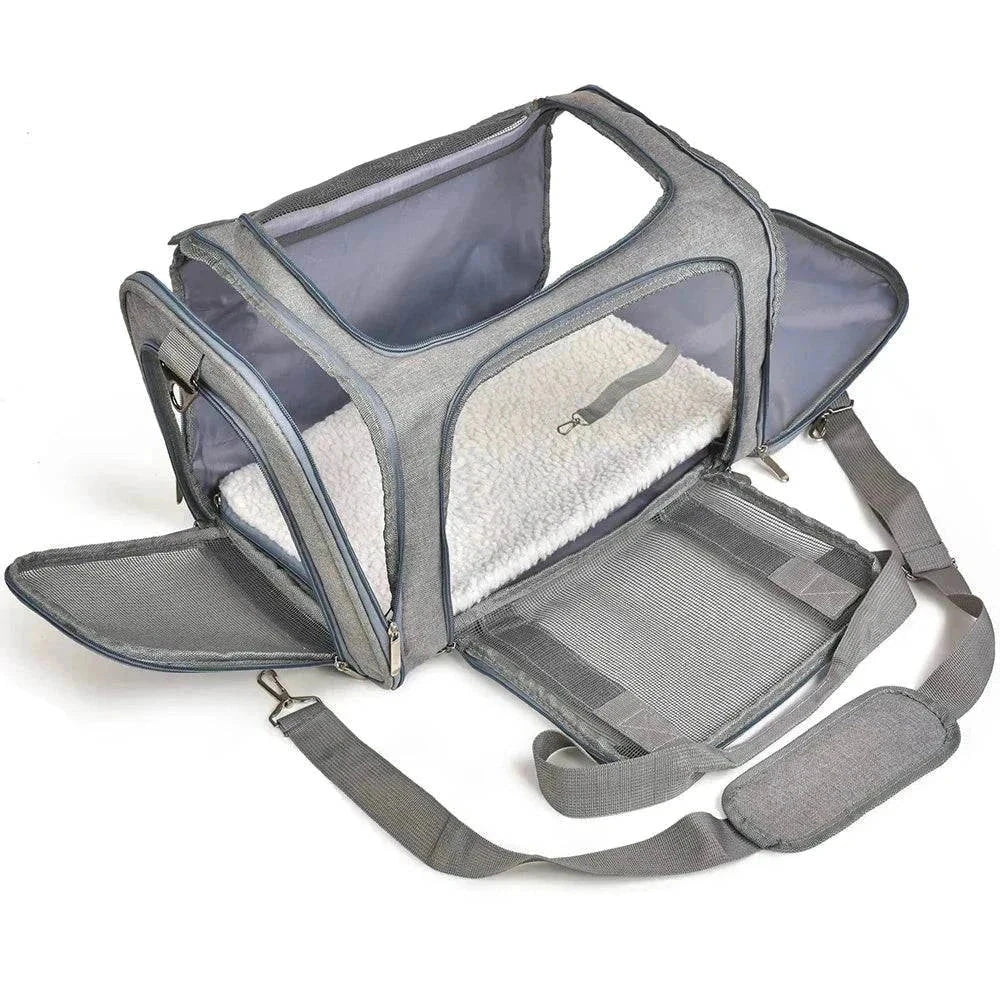 Premium soft-sided pet carrier with mesh panels, padded strap, and removable fleece bed for comfortable travel.